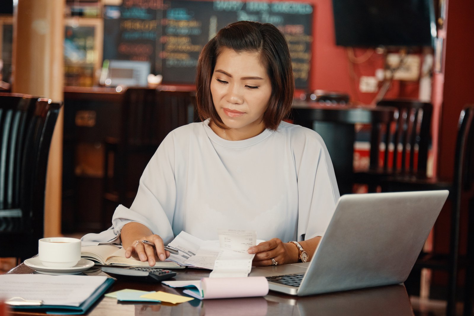 Woman calculating budget for her restaurant